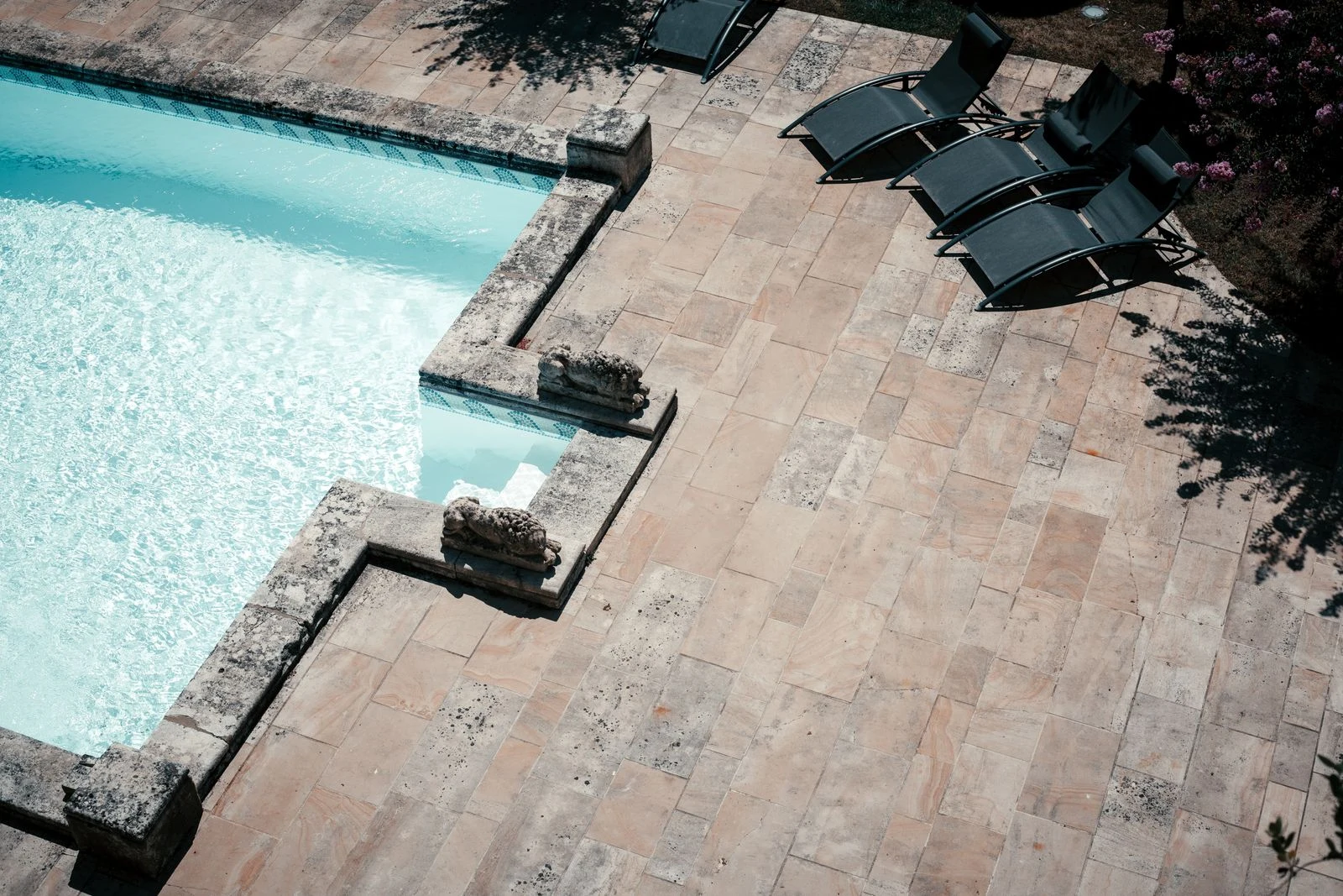 Sun loungers beside a stone-lined swimming pool in Bordeaux, France.